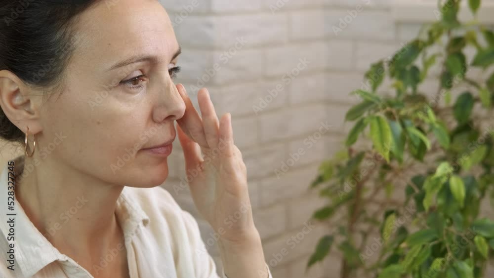 Female self massage for breathing. A nice woman inhaling and make self massage on her face in the room. Female self massage for breathing. A nice woman inhaling and make self massage on her face in the room.
