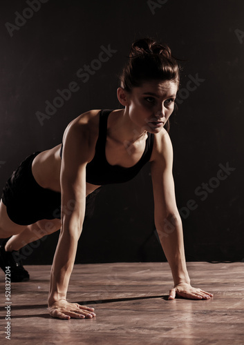 Attractive Sporty Young Caucasian Woman Doing Workout Exercise. Low Key Portrait Photo