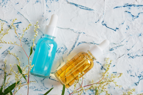 glass dropper bottles and beautiful yellow flowers, natural cosmetic concept