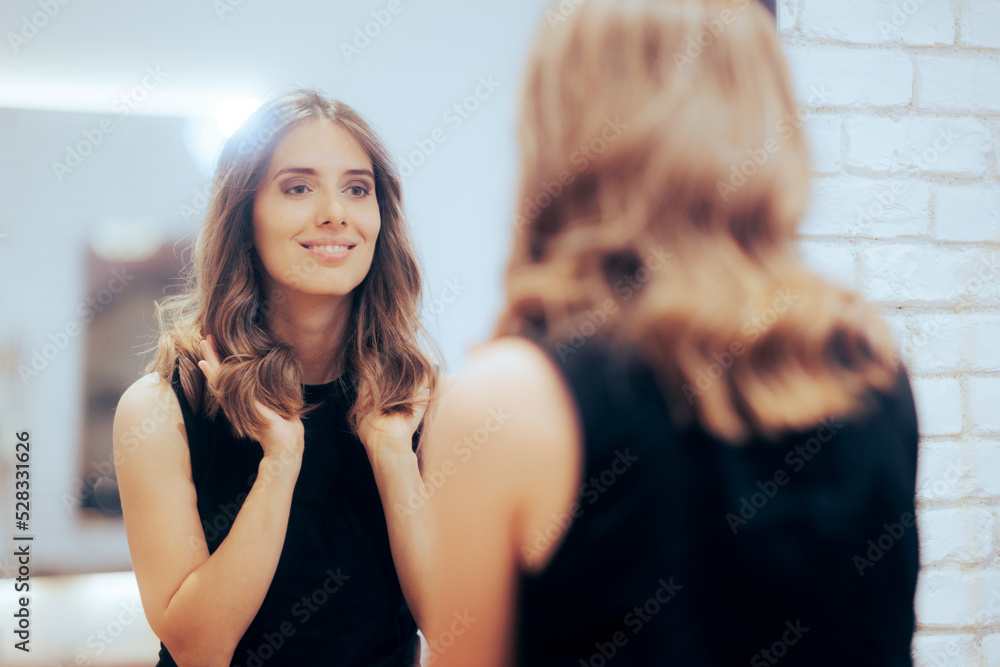 © nicoletaionescu - Woman Admiring Her New Look in the Mirror at a Hair Salon. Happy client loving her new colored coiffure