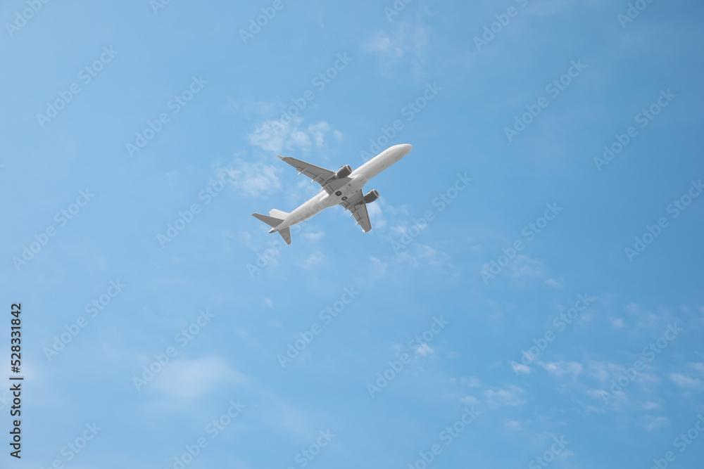 Modern airplane flying in blue sky low angle view Modern airplane flying in blue sky low angle view