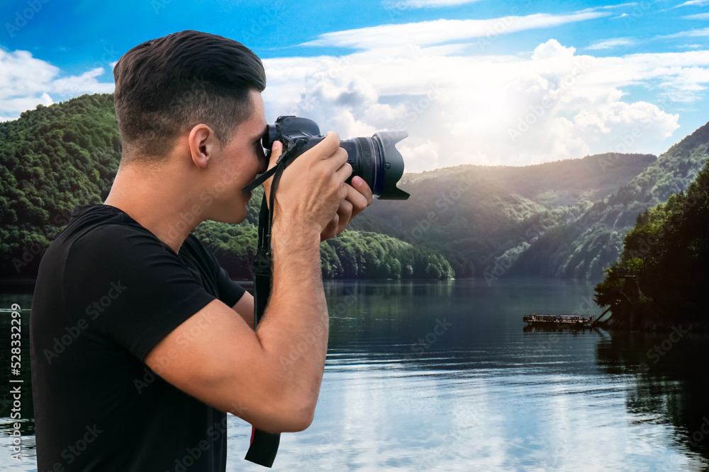 Photographer taking picture of beautiful mountains and riverside with professional camera