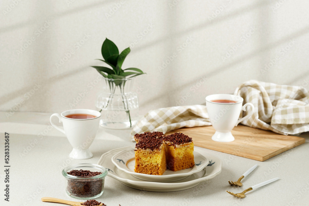 Sliced Mocca Cake with Chocolate Sprinkle Topping, Served with Tea. Sliced Mocca Cake with Chocolate Sprinkle Topping, Served with Tea.
