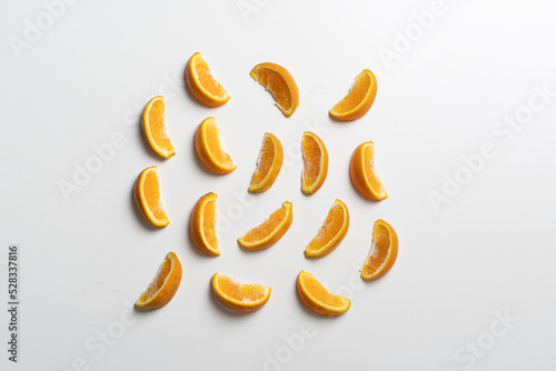 creative layout of orange fruit slices on white surface