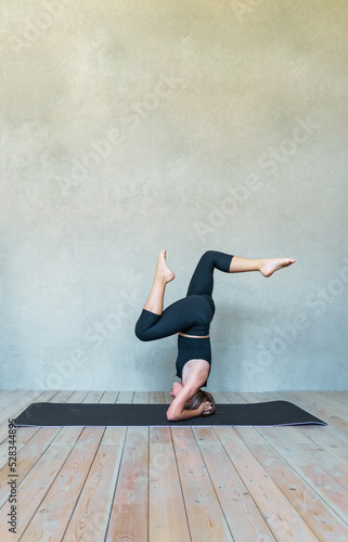 A young girl in sportswear does yoga, fitness at home, sports at home, stretching