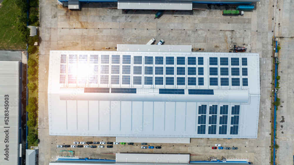 Top view Solar Cell on Warehouse Factory. Solor photo voltaic panels system power or Solar Cell on industrial building roof for producing green ecological electricity. Production of renewable energy. Top view Solar Cell on Warehouse Factory. Solor photo voltaic panels system power or Solar Cell on industrial building roof for producing green ecological electricity. Production of renewable energy.