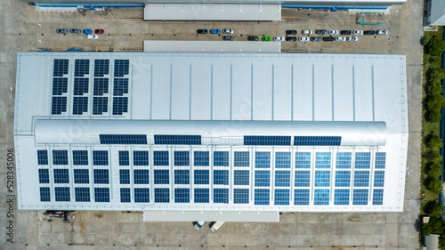 Top view Solar Cell on Warehouse Factory. Solor photo voltaic panels system power or Solar Cell on industrial building roof for producing green ecological electricity. Production of renewable energy.