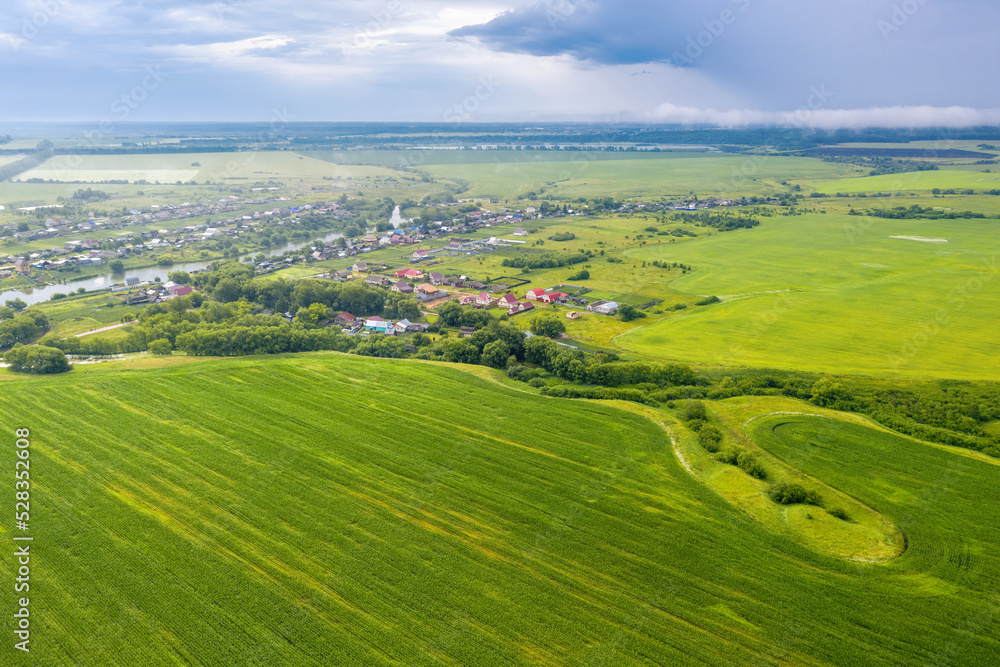 Russian rural landscape. Aerial view of Alekseevka village and surrounding fields on rainy summer day. Penza Oblast, Russia.