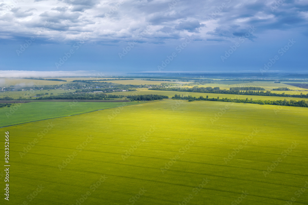 Rural landscape. Aerial view of a field with sunlight on it on rainy summer day. Penza Oblast, Russia.