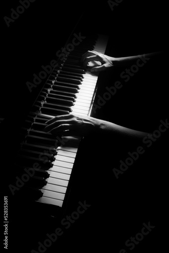 Piano player. Pianist hands playing keyboard isolated on black