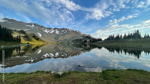 Fototapeta Naklejka Na Ścianę i Meble -  Reflection of mountain in a lake like glass. Blue sky and clouds.