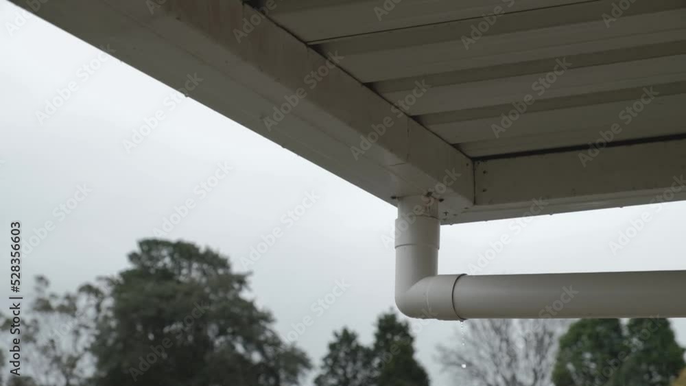 Gutter downspout (or downpipe) dripping water as it overflows during a