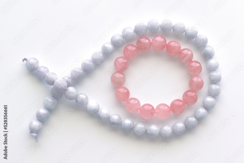 Obraz premium Rose quartz bracelet and aquamarine strand on the table.