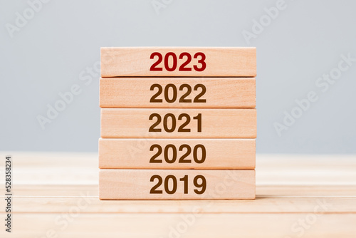 2023 block over 2022 and 2021 wooden building on table background. Business planning, Risk Management, Resolution, strategy, solution, goal, New Year New You and happy holiday concepts