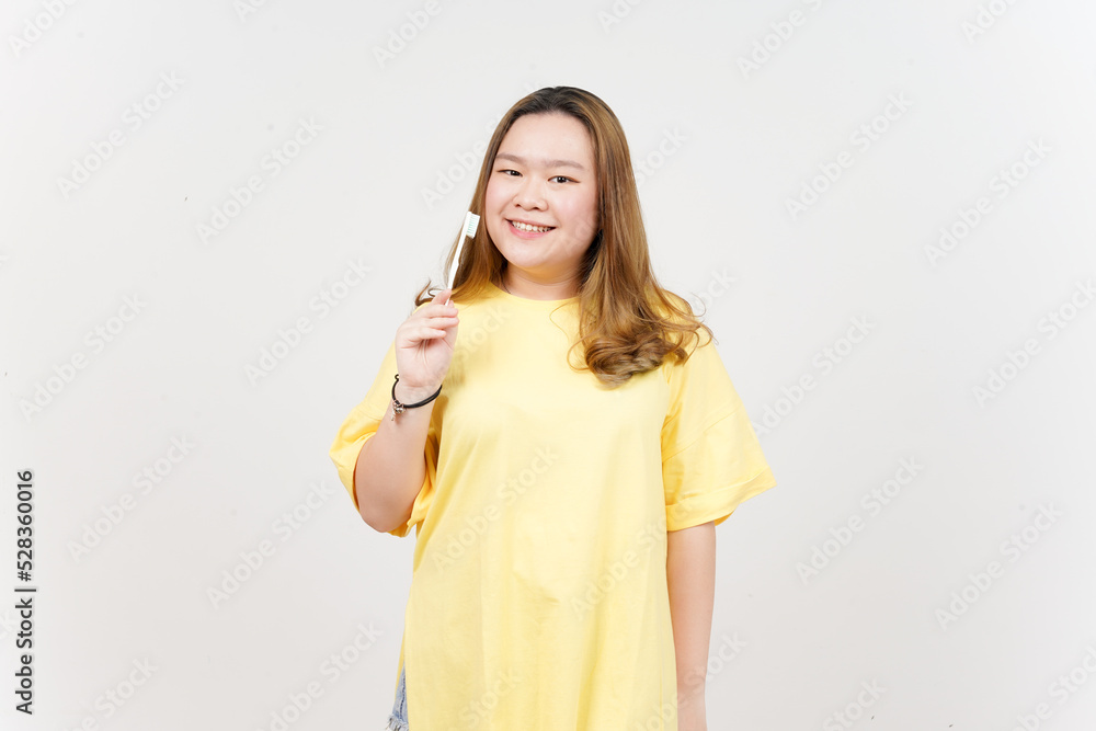Holding toothbrush and smiling to camera of Beautiful Asian Woman wearing yellow T-Shirt Holding toothbrush and smiling to camera of Beautiful Asian Woman wearing yellow T-Shirt