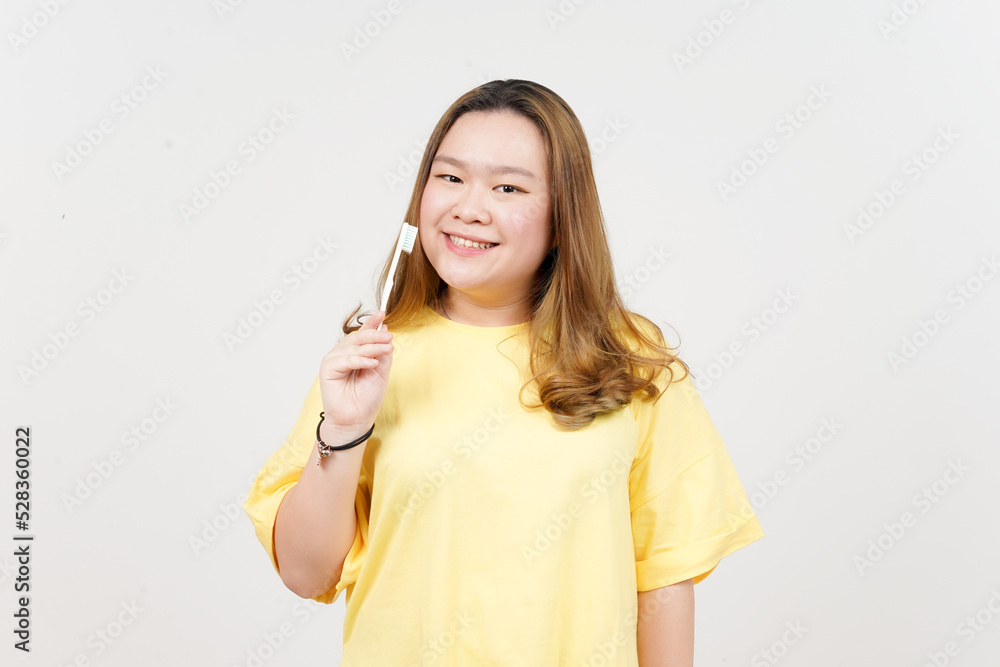 Holding toothbrush and smiling to camera of Beautiful Asian Woman wearing yellow T-Shirt Holding toothbrush and smiling to camera of Beautiful Asian Woman wearing yellow T-Shirt