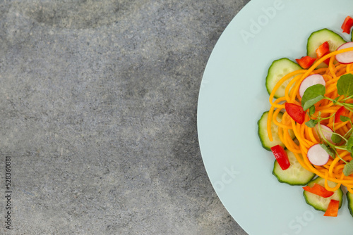 Fresh salad in plate on gray table