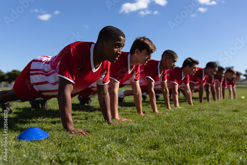 Rugby team doing push-ups on the playing field photo