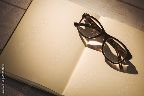 Book with eyeglasses on table