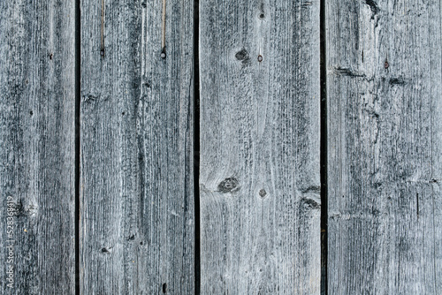 Grey weathered closely packed planks of a wooden fence texture