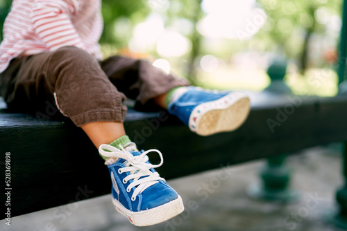 Little baby feet in blue sneakers. Close-up. High quality photo