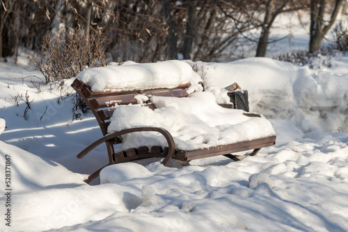 Wooden bench in the city park, winter.