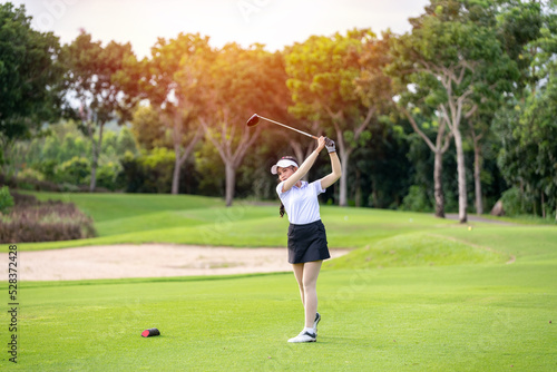 Professional woman golfer teeing golf in golf tournament competition at golf course for winner.