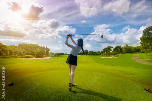 Professional woman golfer teeing golf in golf tournament competition at golf course for winner.