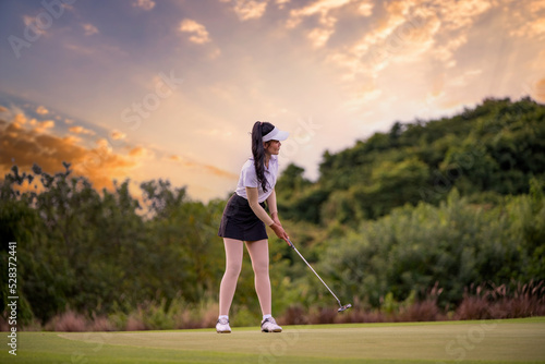 Professional woman golfer teeing golf in golf tournament competition at golf course for winner.