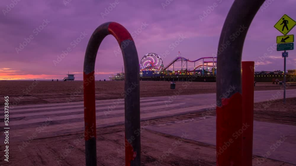 Time Lapse Shot Of Illuminated Pacific Wheel In Famous Amusement Park Seen From Bicycle Parking Station At Beach - Santa Monica, California Time Lapse Shot Of Illuminated Pacific Wheel In Famous Amusement Park Seen From Bicycle Parking Station At Beach - Santa Monica, California