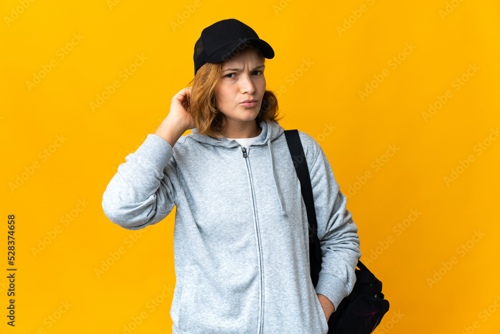 Young sport Georgian woman with sport bag over isolated background having doubts Young sport Georgian woman with sport bag over isolated background having doubts