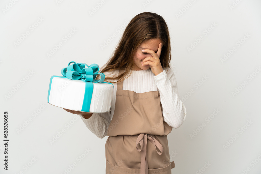 Little girl holding a big cake over isolated white background laughing Little girl holding a big cake over isolated white background laughing