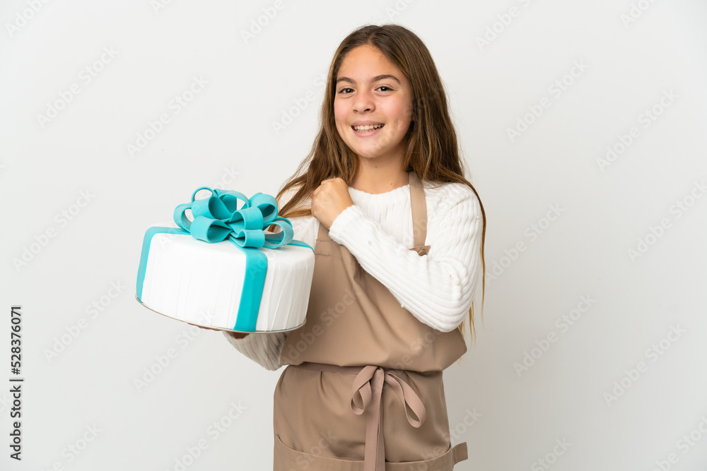 Little girl holding a big cake over isolated white background celebrating a victory Little girl holding a big cake over isolated white background celebrating a victory