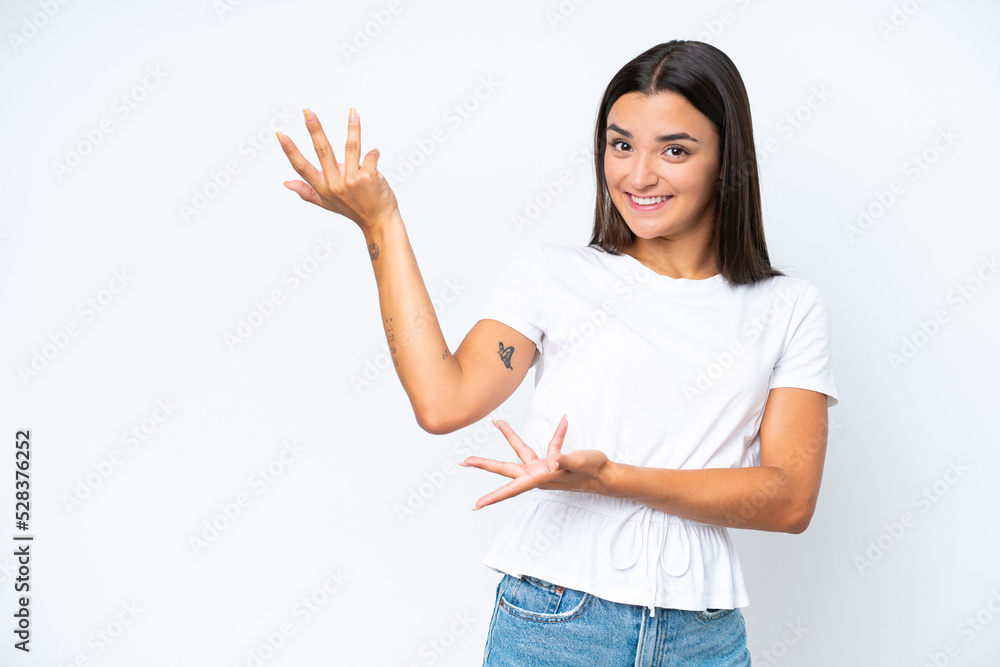 Young caucasian woman isolated on white background extending hands to the side for inviting to come Young caucasian woman isolated on white background extending hands to the side for inviting to come