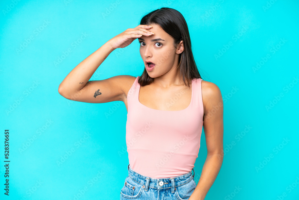 Young caucasian woman isolated on blue background doing surprise gesture while looking to the side Young caucasian woman isolated on blue background doing surprise gesture while looking to the side
