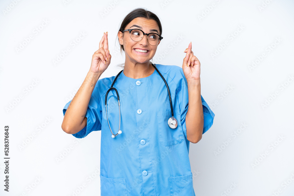 Young nurse woman isolated on white background with fingers crossing Young nurse woman isolated on white background with fingers crossing