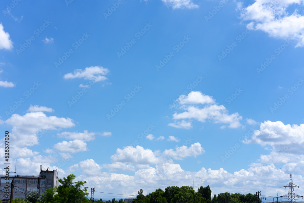 Clear blue sky background with white clouds