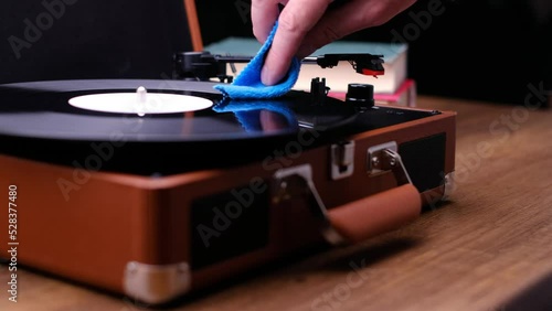 Wipe a vinyl record with a rag, dark background. Turn on the music.