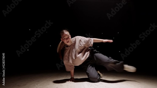 active teen girl is performing modern street dance, dancing freestyle, breaking and hip-hop