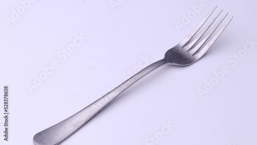 Fork is spinning on the table, cutlery video on a white background.