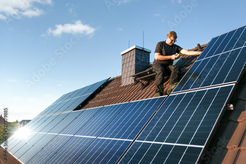 Bild auf Leinwand Technician checking the photovoltaic system on the roof of a house
