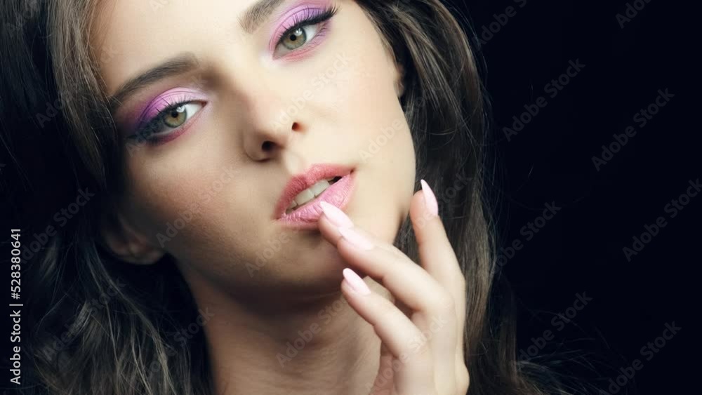 Closeup video of human female face with pink makeup.