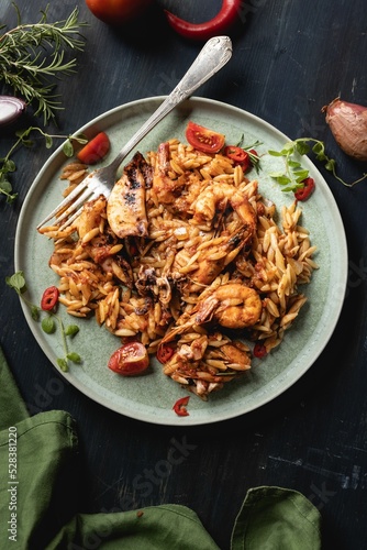 Top view of a decorated plate with delicious pasta made of orzo and shrimps photo