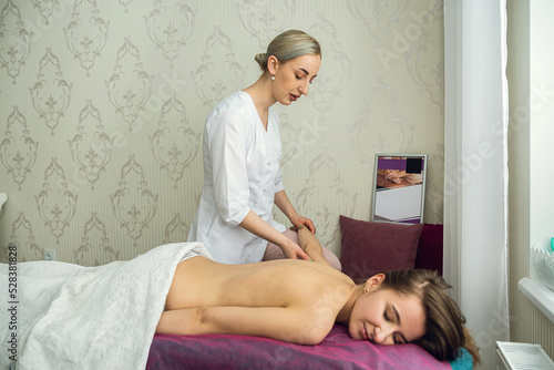 Pretty slim woman receiving a health massage treatment in a spa center