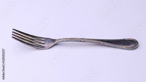 Fork is spinning on the table, cutlery video on a white background