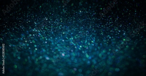 Particles texture background. Bokeh light. Universe stardust. Defocused fluorescent blue green color sparkles on dark futuristic abstract wallpaper.