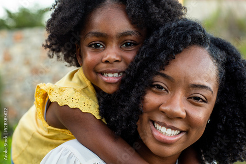 Happy mother and her beautiful daughter smiling.