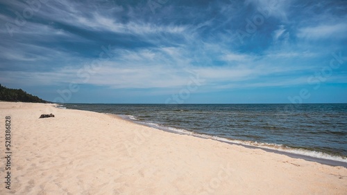 Fototapeta Naklejka Na Ścianę i Meble -  Sandy beach by the Baltic sea waves under blue sky on the horizon