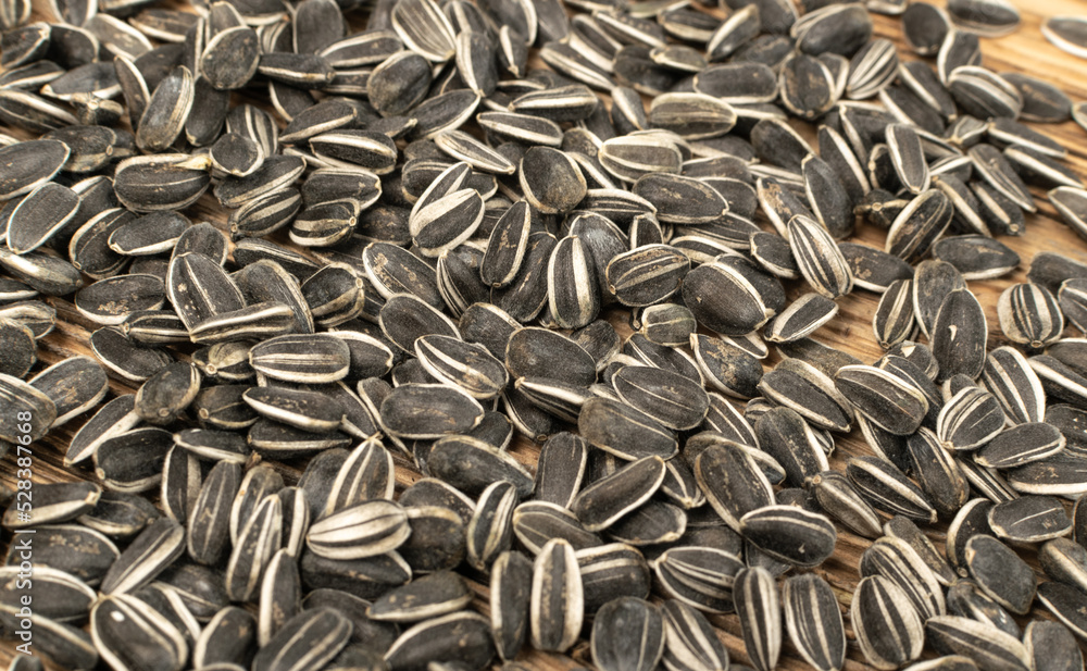 Sunflower Seeds, Striped Raw Seeds on Wood Background Texture Closeup