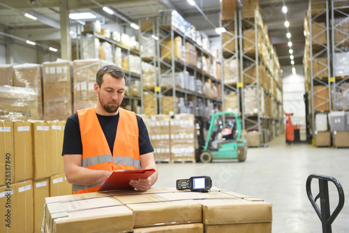 friendly warehouse worker in a warehouse with the barcode scanner